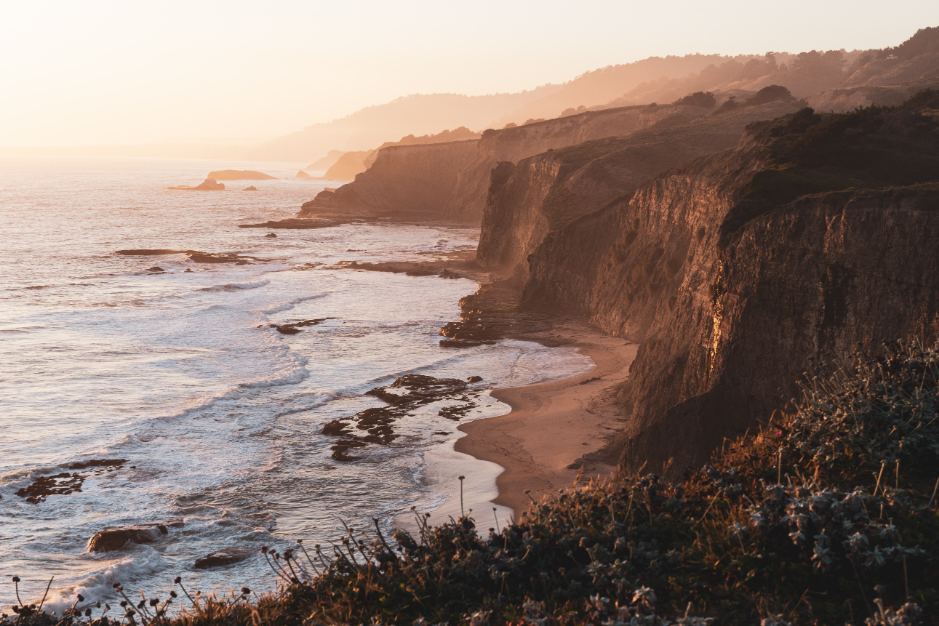 Rocky cliffs overlooking a sandy beach.