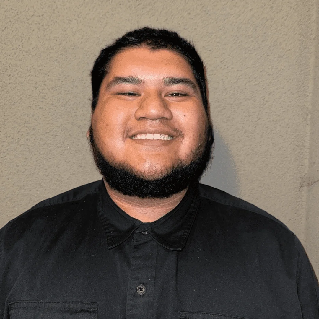 Smiling man with a beard wearing a black shirt.